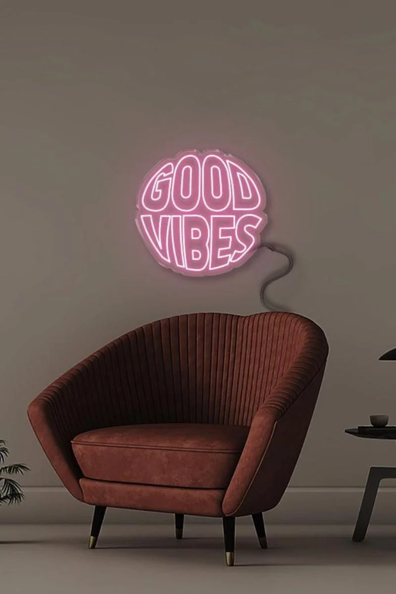 Silla con letrero de neon 'good vibes'